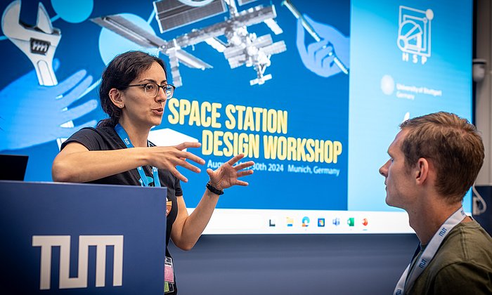 Teilnehmende unterhalten sich auf dem Space Station Design Workshop