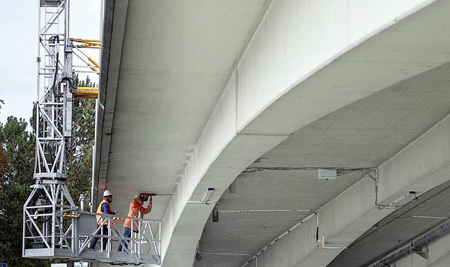 Zwei Forschende installieren Ultraschall-Sensoren an der Unterseite der Gänstorbrücke zwischen Ulm und Neu-Ulm 