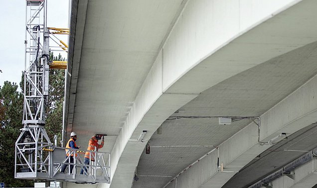 Zwei Forschende installieren Ultraschall-Sensoren an der Unterseite der Gänstorbrücke zwischen Ulm und Neu-Ulm 