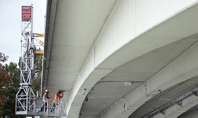 Zwei Forschende installieren Ultraschall-Sensoren an der Unterseite der Gänstorbrücke zwischen Ulm und Neu-Ulm 