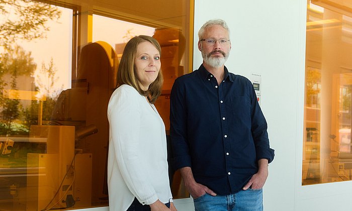 Johanna Eichhorn und Ian Sharp vor einer Wand mit orangefarbenen Scheiben