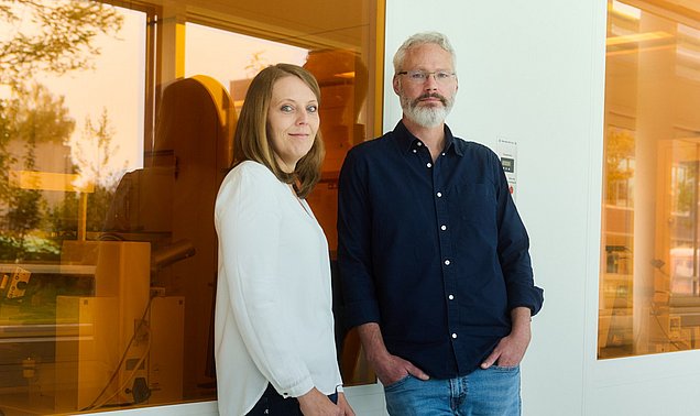 Johanna Eichhorn und Ian Sharp vor einer Wand mit orangefarbenen Scheiben