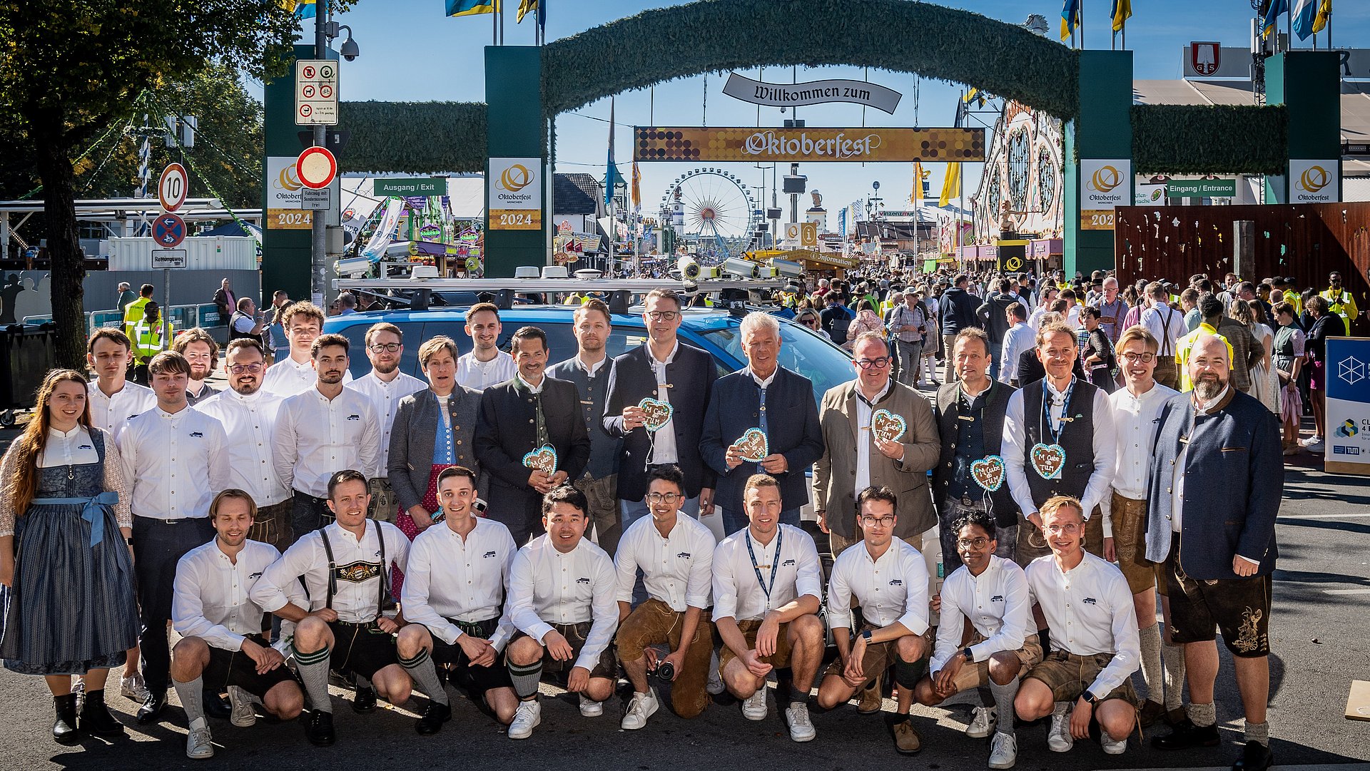 The entire team poses in front of the Wiesn Shuttle in front of the Oktoberfest