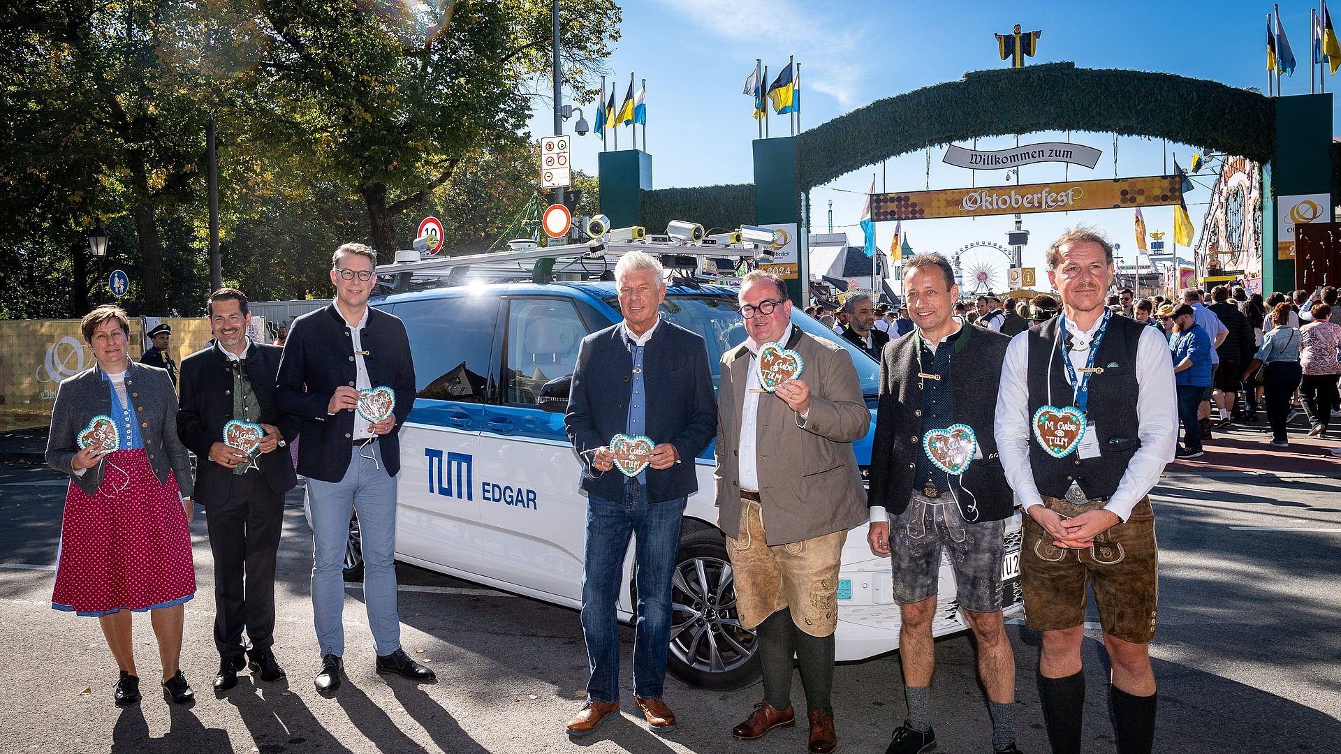 Geladene Gäste vor dem Wiesn Shuttle, im Hintergrund ist das Oktoberfest zu sehen