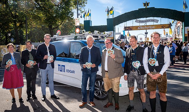 Geladene Gäste vor dem Wiesn Shuttle, im Hintergrund ist das Oktoberfest zu sehen