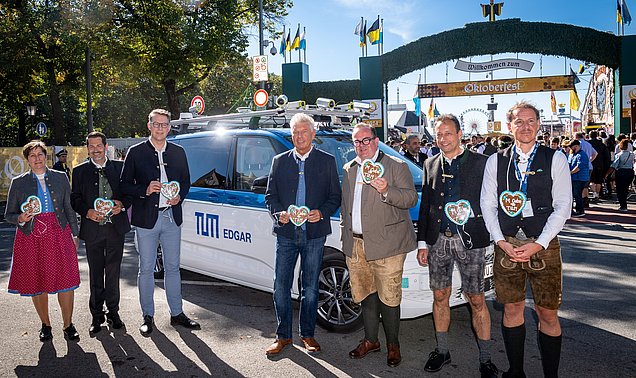 Geladene Gäste vor dem Wiesn Shuttle, im Hintergrund ist das Oktoberfest zu sehen