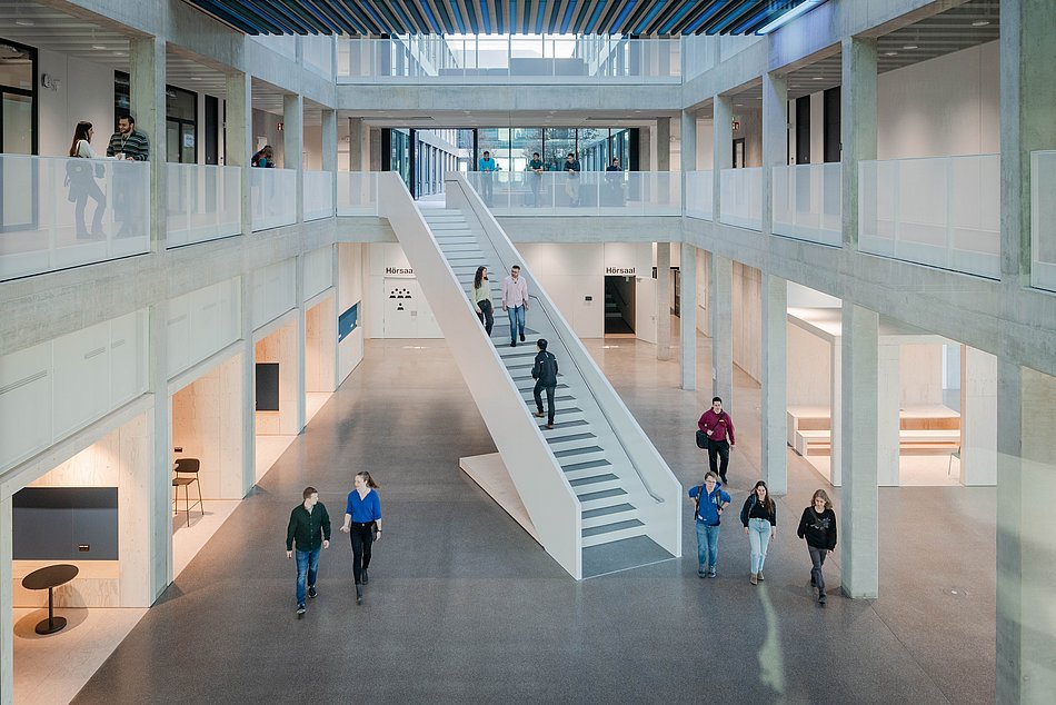 Studierende gehen durch die Halle im Neubau der Fakultät für Elektrotechnik und Informationstechnik der TUM am Campus Garching (Bild: Andreas Heddergott / TUM).