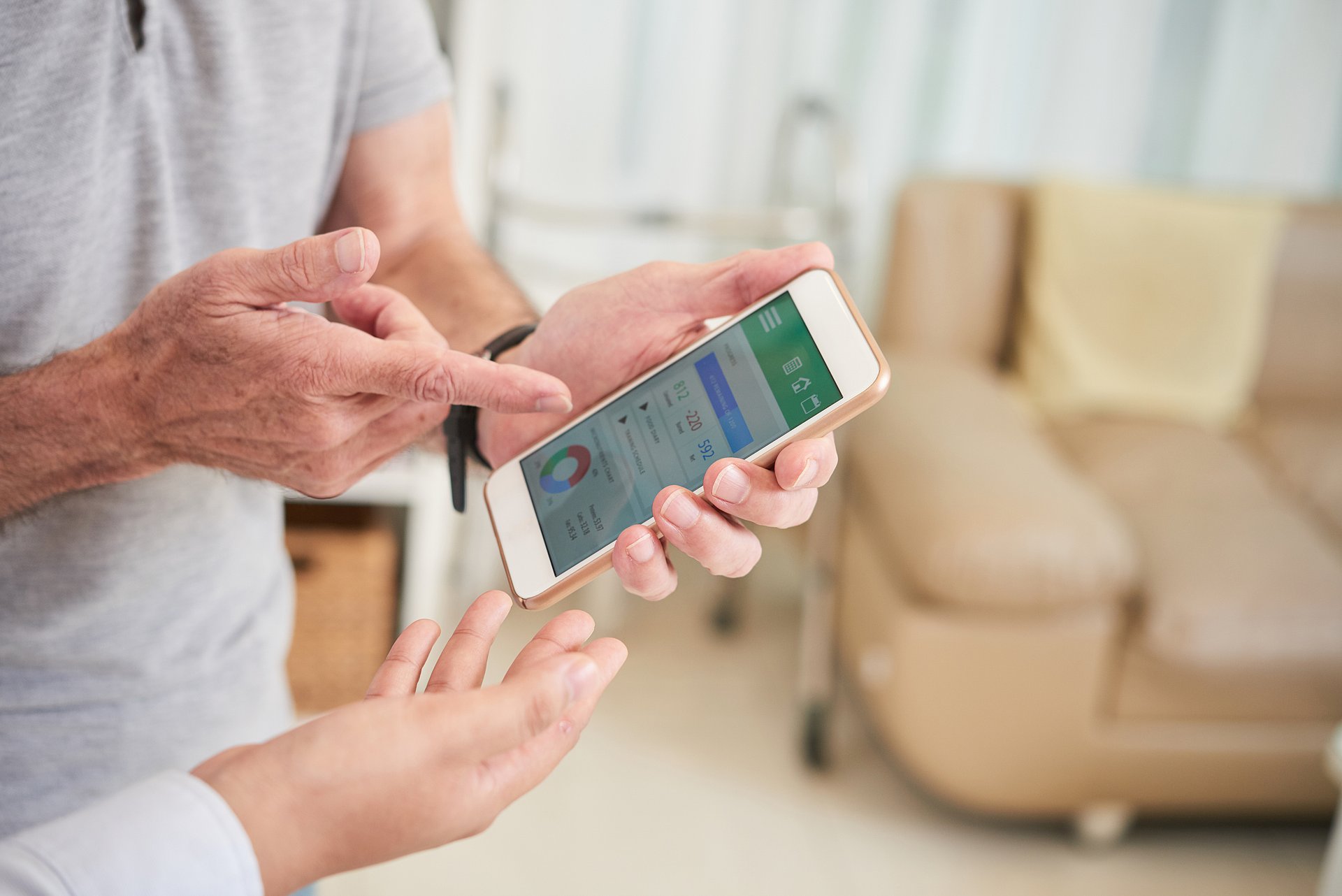 An elderly person discusses health data on a smartphone with a doctor.