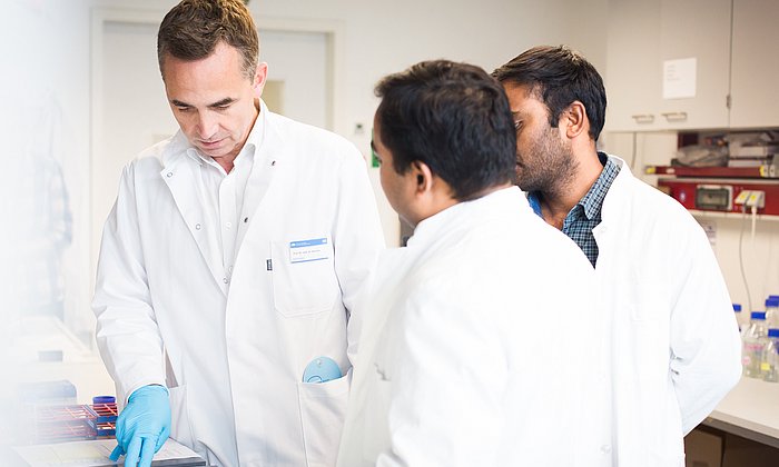 Mediziner Prof. Bernhard Hemmer mit zwei Mitarbeitern bei der Arbeit.