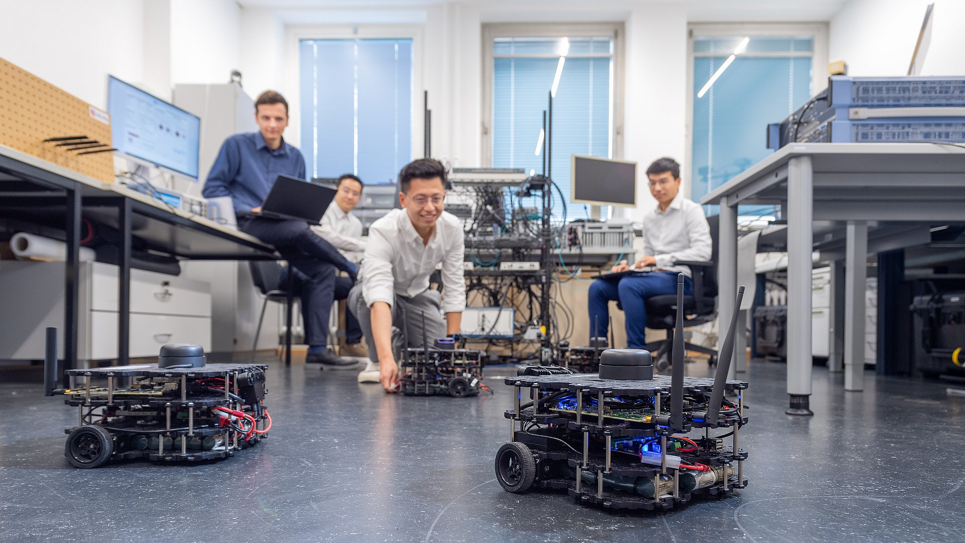 Four driving robots move around the laboratory in a coordinated manner, whereby the use of a sensing-assisted digital twin enables the robots to be localised by modelling radio wave propagation.