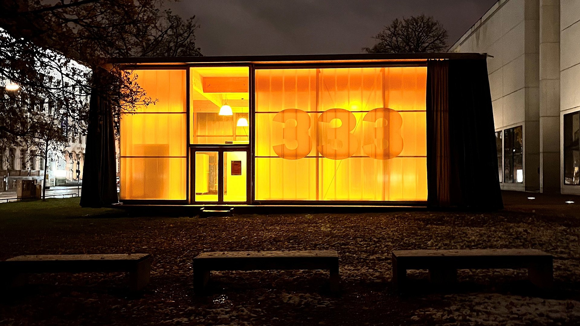 Exterior view of Pavilion 333 next to the Pinakothek der Moderne at night.