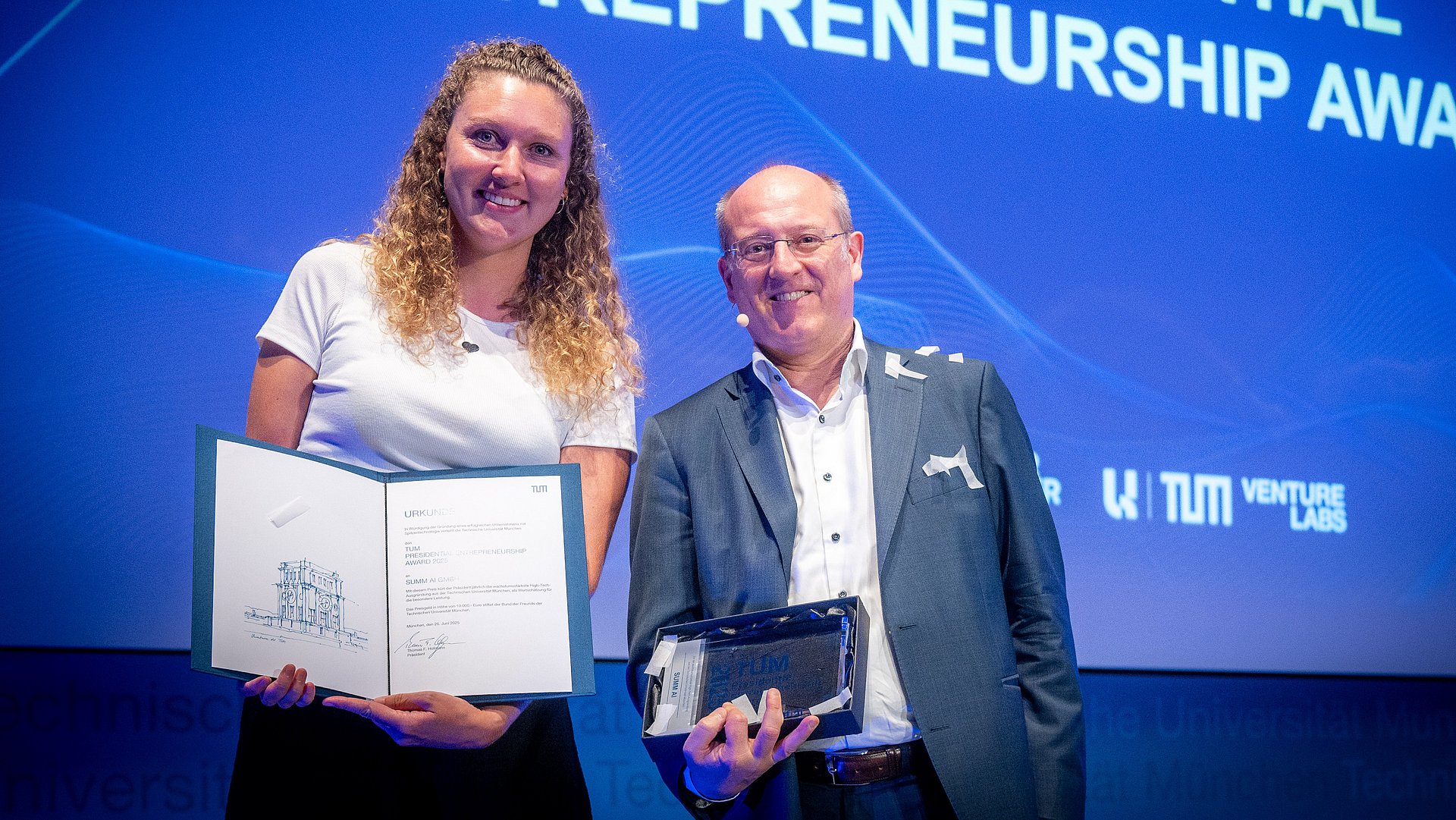 Vice President Prof. Gerhard Kramer presents the TUM Presidential Entrepreneurship Award to Flora Geske, founder of the start-up SUMM AI. Vice President Prof. Gerhard Kramer presents the TUM Presidential Entrepreneurship Award to Flora Geske, founder of the start-up SUMM AI.